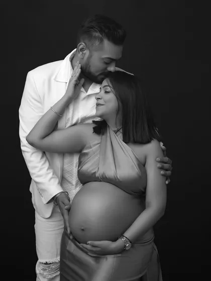 Pure love in every frame. This black and white portrait captures a tender moment, with the dad-to-be placing a gentle kiss on his partner's forehead.