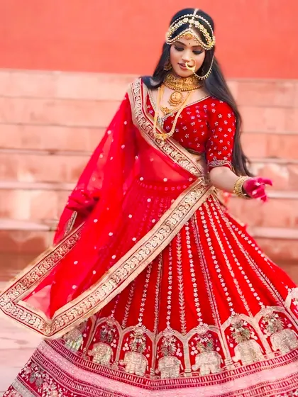 This is the quintessential bridal look. Our classic red lehenga, rich in detail and tradition, is perfect for the bride who wants to feel like royalty on her wedding day. This piece is available for rent, making your dream wedding look a reality.