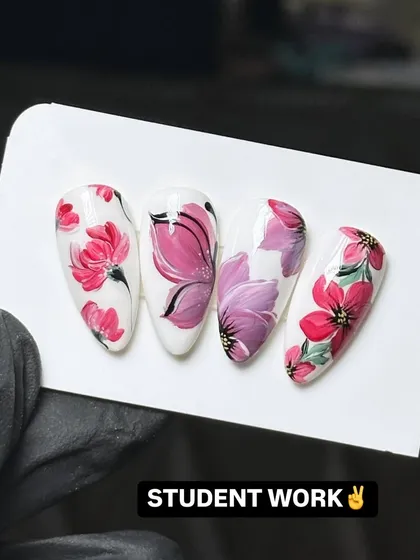 This is the level of detail and artistry my students achieve. This example of student work shows intricate, hand-painted floral designs on almond-shaped nail tips, demonstrating the high-quality techniques taught in my nail art design workshops.