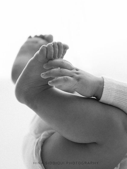 Those tiny feet they love to grab! This detailed black and white shot focuses on the adorable milestone of discovering their own toes. It’s these little moments that make the six month session so special.