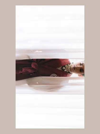 A creative and abstract bridal portrait, shot through blinds. This technique creates a sense of mystery and anticipation, focusing on form and light.