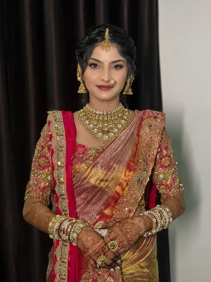 A portrait of the bride, showcasing her soft glam makeup and heavy gold jewellery.