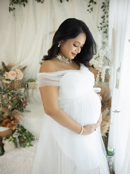 A lovely portrait of a mother-to-be with an elegant pearl necklace. The details of her accessories complement the pure and classic all-white look.
