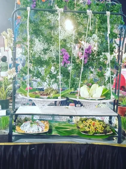 A creative salad bar setup using a swing design with hanging floral arrangements, perfect for garden parties and whimsical wedding themes.