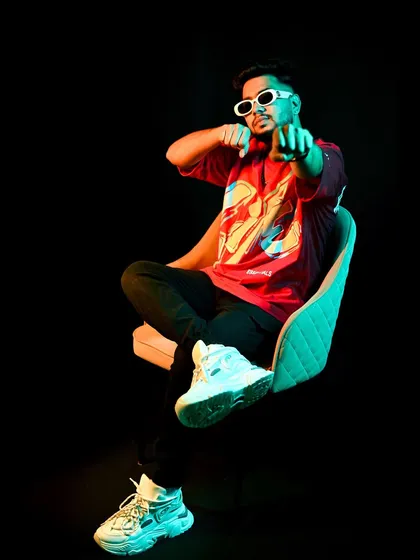A shot from a recent photoshoot, playing with colored lighting. The glow and the pose reflect the vibrant, dynamic energy of my tracks.