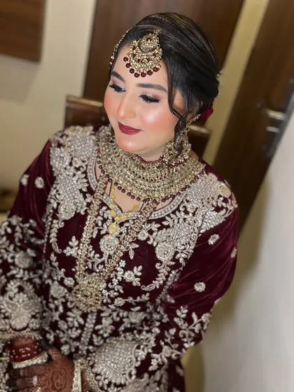 A slightly different angle, showing the beautiful hair updo and the placement of the maang tikka. Every detail is considered to ensure the bride looks and feels her absolute best.