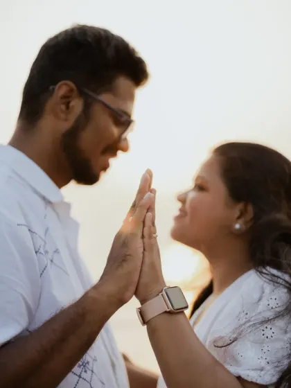 A close-up of the couple's hands coming together, a simple yet powerful gesture of unity and connection.