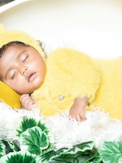 Just hatched! This newborn is sleeping peacefully inside a giant eggshell, dressed in a fluffy yellow chick costume.
