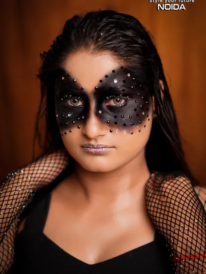 A direct portrait of the black mask fantasy look. The intense gaze and silver glitter lips create a powerful and captivating image.