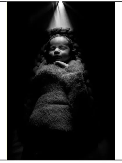 This is an example of my artistic newborn photography. Using dramatic lighting and a soft wrap, I create powerful, fine art portraits that highlight the serene beauty of your sleeping baby.