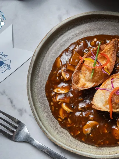 A comforting and savory dish perfect for any buffet. These pan-fried chicken dumplings are served in a rich, simmered mushroom broth, offering a delicious fusion of Asian flavors that warms the soul.