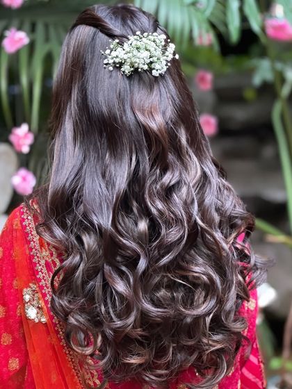 A simple twist with baby's breath is all you need to elevate soft, bouncy curls. This hairstyle is effortlessly romantic.