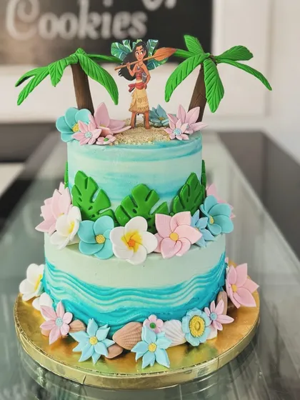 A beautiful two-tiered Moana cake that captures the spirit of the ocean. The design includes tropical flowers, waves, and a fondant Moana figure, perfect for a themed party.