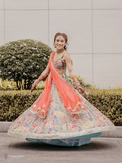 The bride twirls in her multi-colored lehenga, a perfect shot to showcase the beauty and fun of her Mehendi outfit.