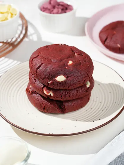 A stack of red velvet cookies shot in bright, hard light to create sharp shadows. This modern, high-contrast look is perfect for social media and grabs attention.