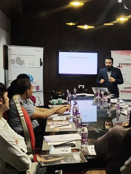 Here I am discussing Crisaborole, a newer treatment for Atopic Dermatitis, with a group of fellow doctors. Staying updated on new medications allows me to offer the most current and effective options to my patients.