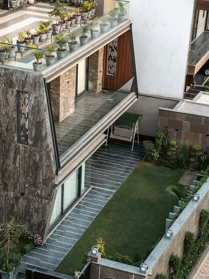 An overhead view of Club Drive House reveals the private garden and terrace spaces created by the home's layered volumes. The rooftop is thoughtfully designed with potted plants, extending the greenery vertically.
