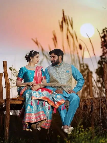 A beautiful sunset shot of a couple in traditional Indian attire. The vibrant colors of their outfits look stunning against the warm, golden light.