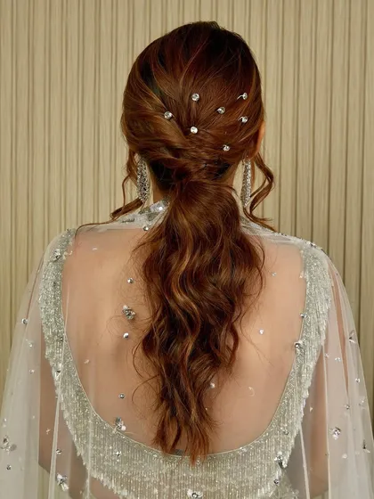 It's all in the details. This glamorous ponytail is perfect for a reception or cocktail party, featuring soft waves and sparkling crystal accents scattered throughout for that extra touch of shimmer.