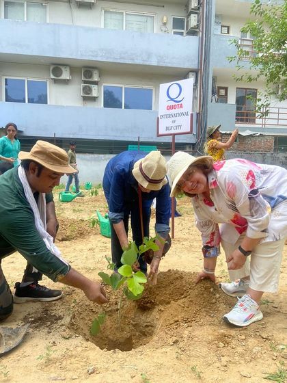 A member of Quota International and our team guide school children in planting a sapling, fostering a connection between generations.