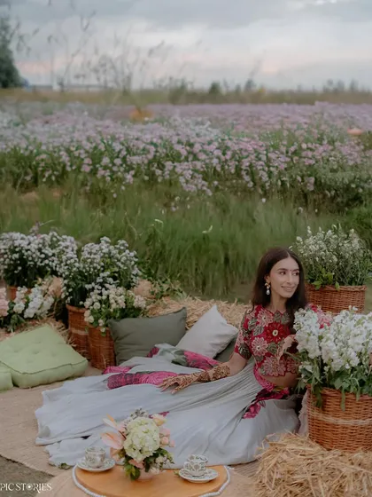 A wide shot of the bride enjoying a picnic-style Mehendi setup. This photo captures the relaxed and beautiful atmosphere of the event, showing more than just a portrait but a whole experience.