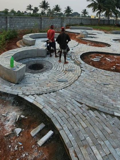 The intricate pattern of the stone path begins to take shape. This work-in-progress shot shows the flowing lines of the walkway and integrated seating, which will soon be nestled within dense, naturalistic planting.