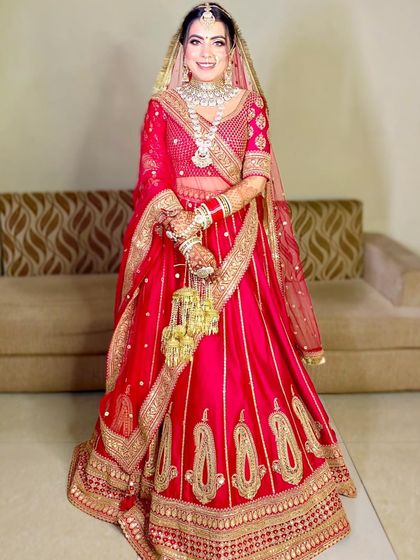 The full bridal look for Neha in her stunning red lehenga with paisley embroidery.