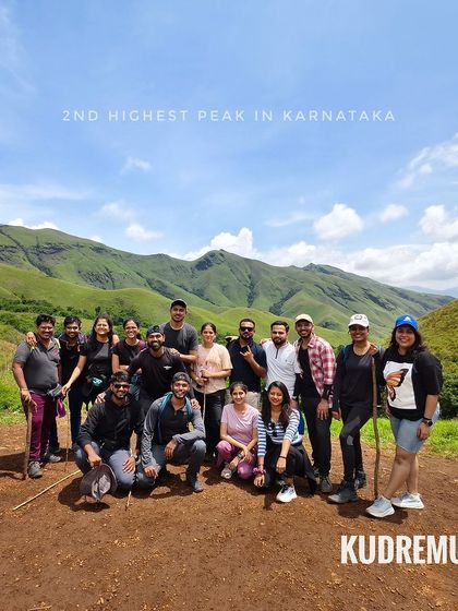 A fantastic group photo on the Kudremukha trail, showcasing the vast, rolling green hills that define this trek. It's the second highest peak in Karnataka for a reason.