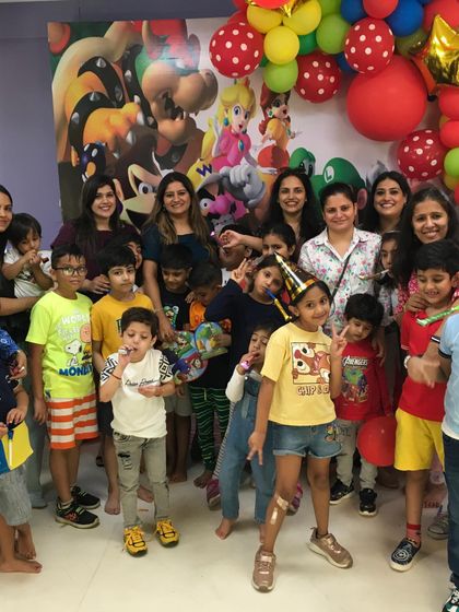 The whole crew is here! A happy group of kids and parents celebrating at Krishav's fun-filled Super Mario birthday bash.