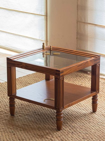 Different views of the Kulam collection, including the side table and center table. These images showcase the blend of solid teak, glass, and narrative brass accents that define this collection.