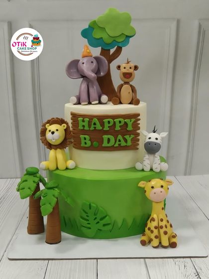 A two-tiered jungle adventure cake perfect for a young explorer's birthday. We decorated it with friendly, handcrafted fondant animals like a lion, elephant, and giraffe to create a fun and delicious centerpiece.