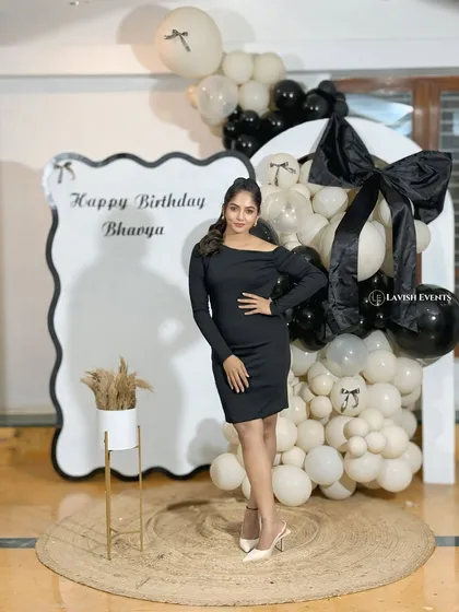 The birthday girl posing confidently in front of her chic party decor.