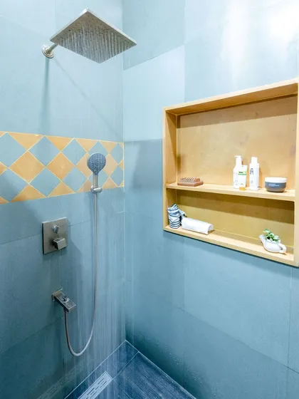 A patterned tile accent in yellow and blue adds a decorative touch to the shower area.