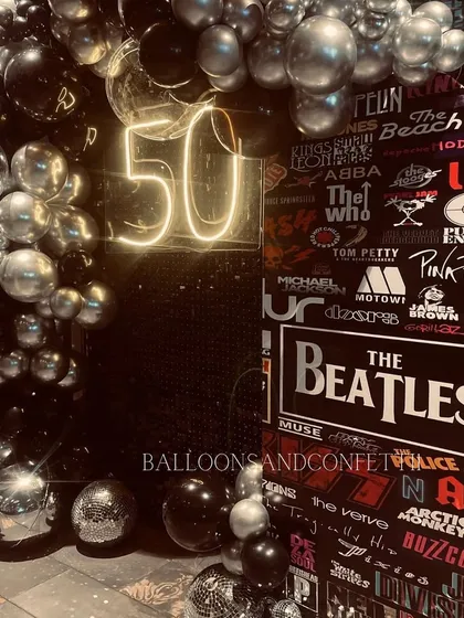 A closer look at the rockstar-themed decor, showing the details of the band poster wall and the metallic balloon arch.