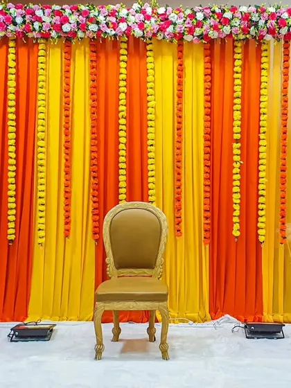 This colorful and energetic backdrop is perfect for a haldi or mehendi. The bright drapes and floral border create a picture-perfect setting.