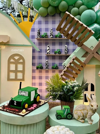 The tractor-themed birthday cake and miniature tractor models displayed in front of the barn's interior.
