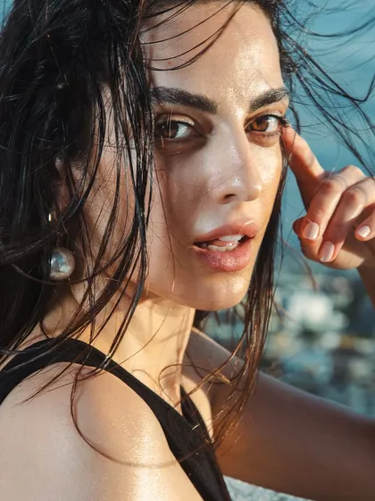 This close-up highlights the glossy eye and skin finish. The minimal makeup approach ensures the focus remains on the raw, natural beauty and the textures of the hair and skin.
