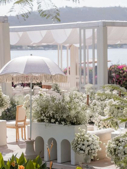 For this Anand Karaj by Lake Pichola, we used an all-white theme with baby's breath flowers and elegant umbrellas to create a serene, dream-like atmosphere.