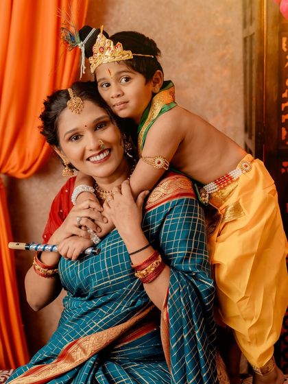 A mother's love for her little Krishna. This candid moment captures the joyful bond between mother and son during a festive shoot.