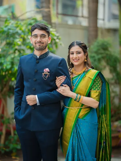 An elegant portrait of the couple in a garden setting. The groom has his hand in his pocket for a relaxed yet stylish pose.