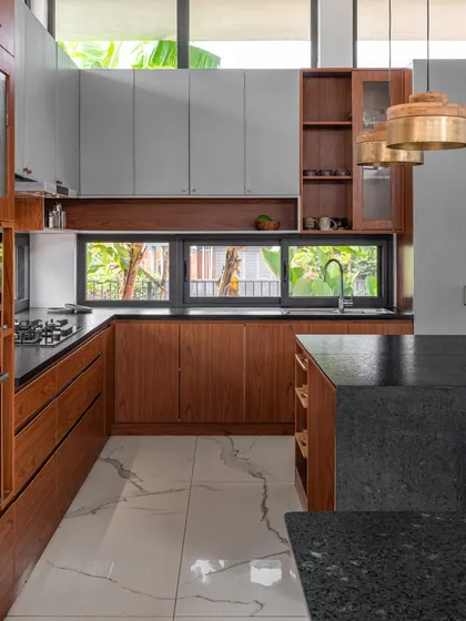 The U-shaped kitchen in the SAMAM House, designed for functionality and connection. A low-level window provides views of the garden, while the layout opens towards the dining area, keeping the space social and integrated.