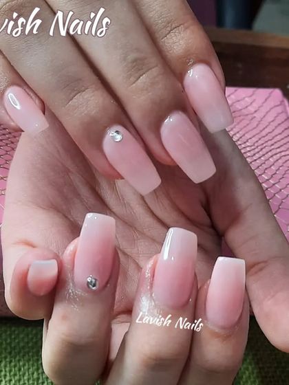 Simple and elegant milky pink coffin nails with a single, subtle rhinestone accent.