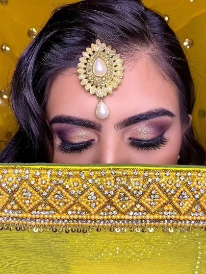 A close-up of this stunning Roka makeup. The focus is on the dramatic purple and gold smokey eye, blended perfectly for a captivating look. This highlights my skill in creating detailed and intricate eye makeup for special events.