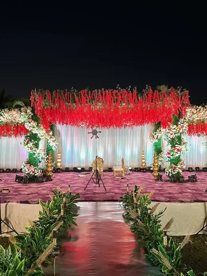Another view of the stunning red floral ceiling reception stage, showcasing the scale and impact of the design. The lighting enhances the richness of the red, creating a vibrant and celebratory mood.