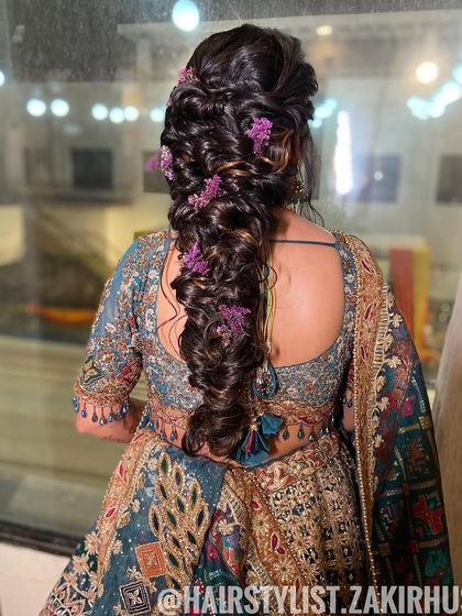 A stunning, voluminous bubble braid decorated with delicate purple flowers. This intricate hairstyle is perfect for a bride who wants a dramatic and unique look for her special day.