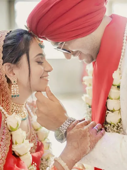 A tender moment during a Punjabi wedding ceremony. The groom's gentle touch and the bride's serene smile create a timeless portrait of love and affection.