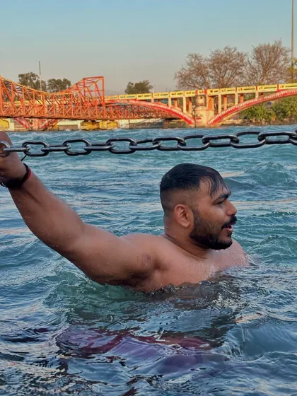 Holding onto the chains for support in the fast-flowing river at Haridwar. A test of strength in a natural setting.