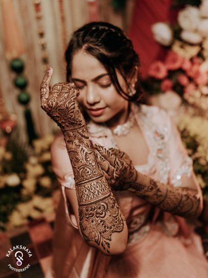 A beautiful close-up showcasing the intricate and artistic Mehendi design on the bride's arms.