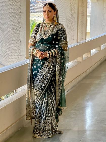 A royal bride in a deep green Manish Malhotra saree. I styled her hair in a classic updo to match the regal elegance of her outfit.