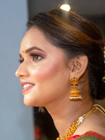 A dreamy, glowing look for a special day. The side profile shows the elegant twisted bun and the beautiful highlight on her cheekbones.